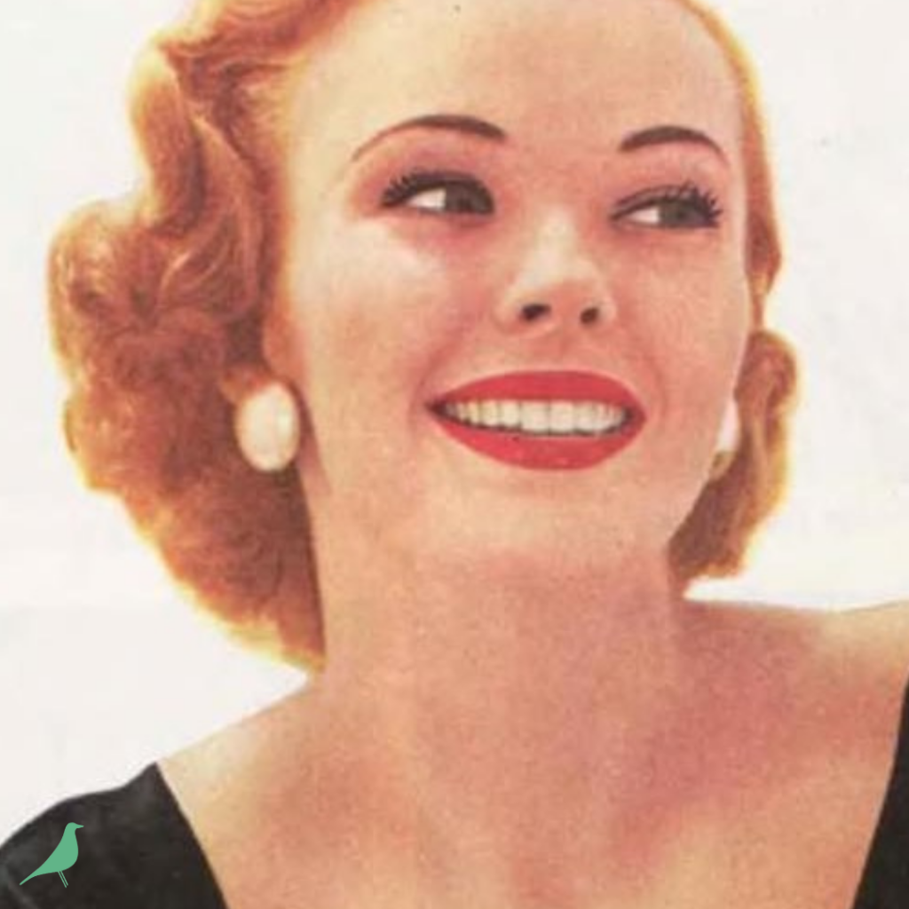 A cropped and enlarged view from a vintage magazine photo of a lady with vintage-style curled hair, smoky eyes, red lips, large pearly earrings, and a black velvet top, showing feminine appearance for the chapter-by-chapter summary series of Always Ask a Man: the Key to Femininity by Arlene Dahl. Series written by Mid-Century Modern Mommy; photo contains the teal House Bird logo of Mid-Century Modern Mommy in lower left corner.